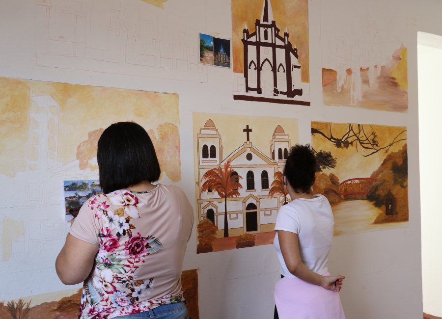 Artista faz pinturas ilustrativas na sala de recepção da Secretaria de Turismo